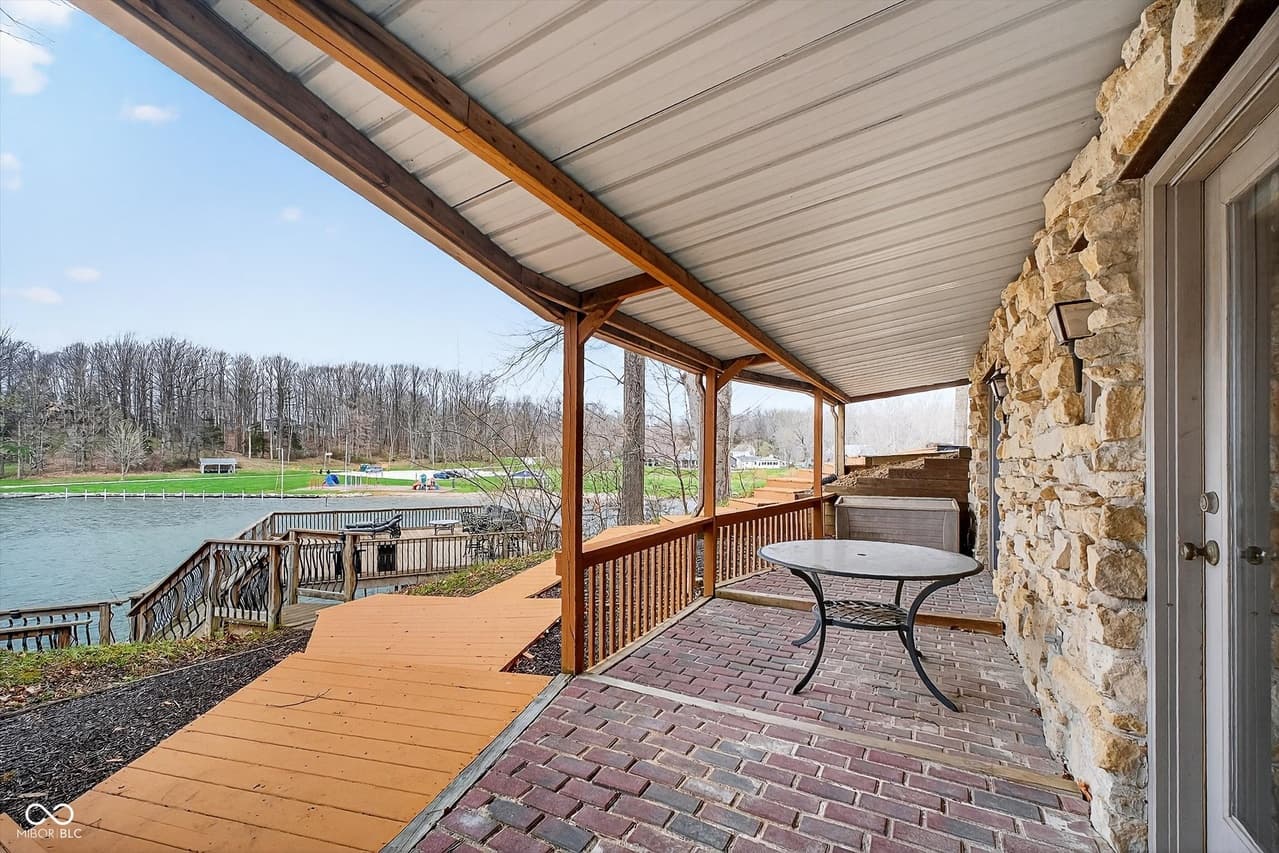 Covered lakeside patio with stone wall